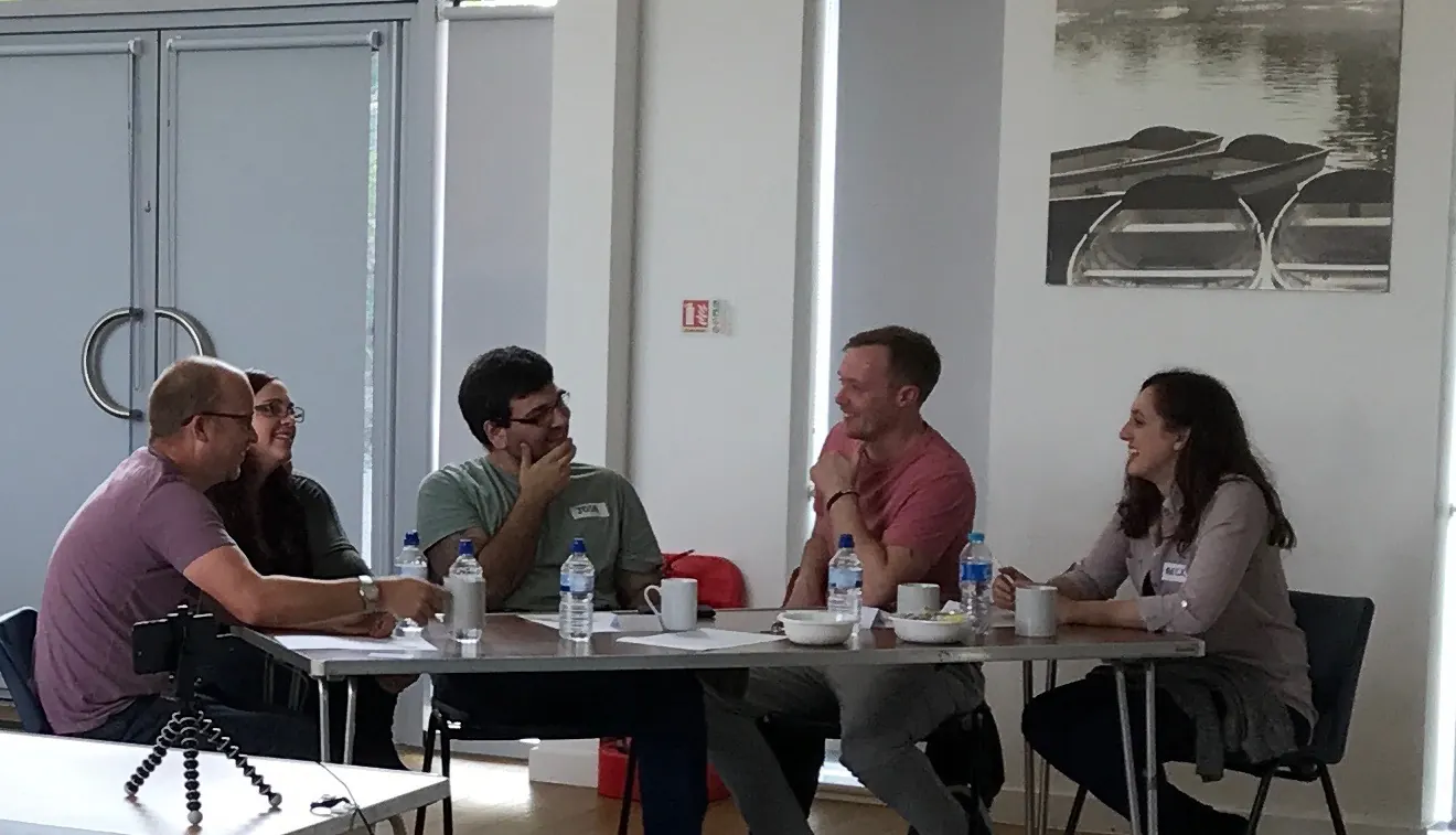 Small group talking around a table during the Emotional Fitness Perceptual Positions course