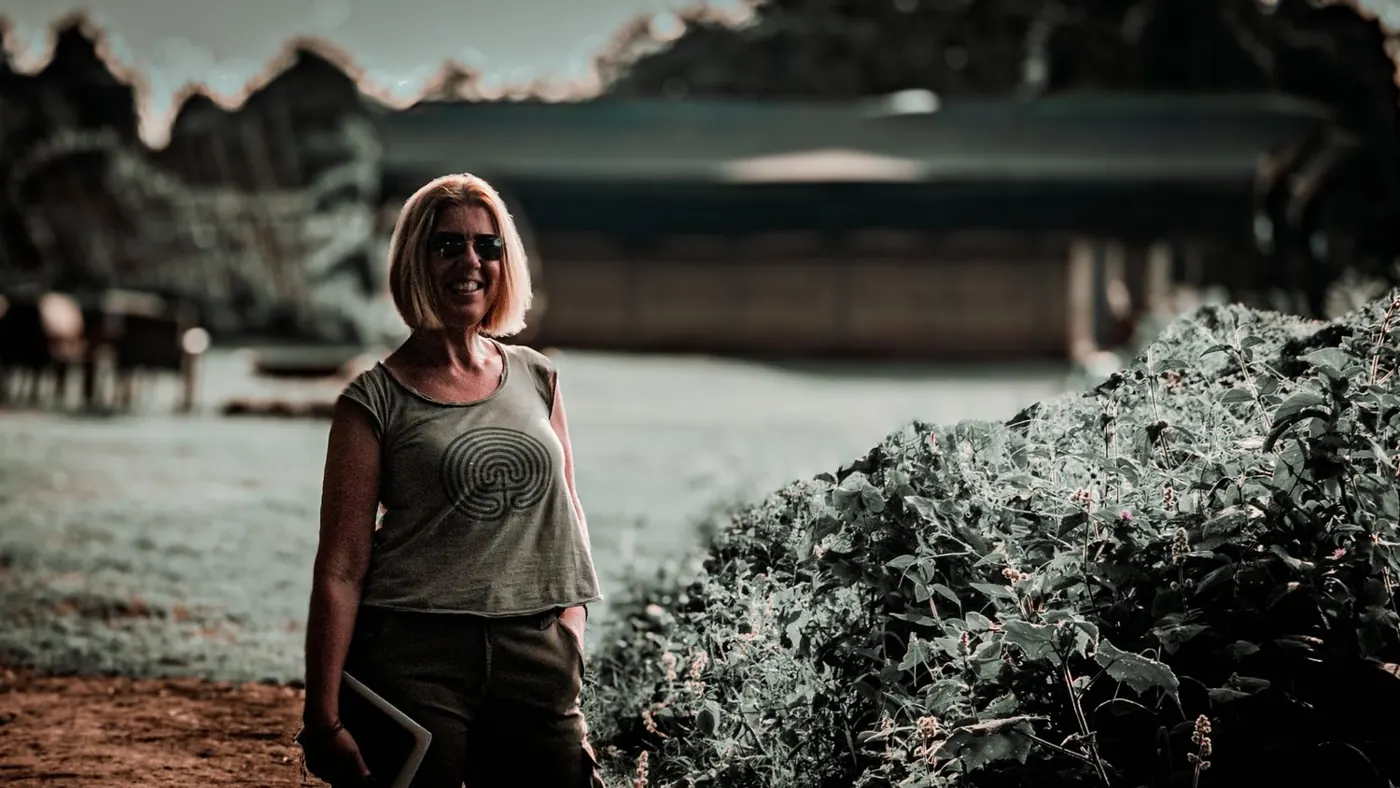 A smiling woman in sunglasses outside a safari camp